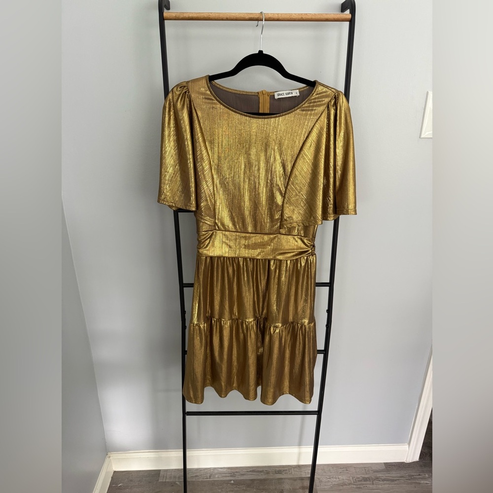 This dress is a shimmering gold piece made from a metallic fabric.